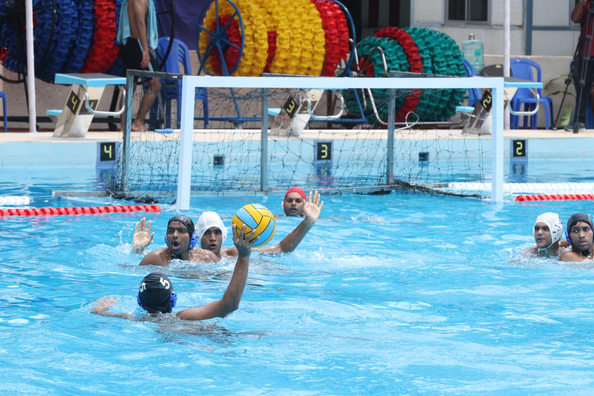 players playing water pollo with attacker trying to shoot past a defender